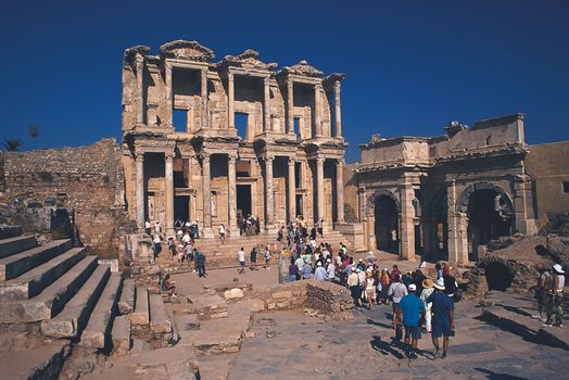 Crowds gather at the ancient Library of Celsus ruins in Ephesus, Turkey, a popular tourist destination.