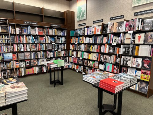 A bookstore with books on the shelves and tables