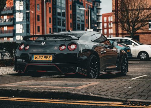 Free Black Nissan GT-R parked in a modern city environment showcasing luxury and performance. Stock Photo