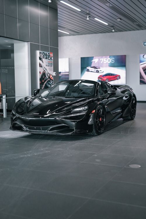 Free A stunning black sports car showcased in a modern luxury showroom setting, exuding elegance. Stock Photo