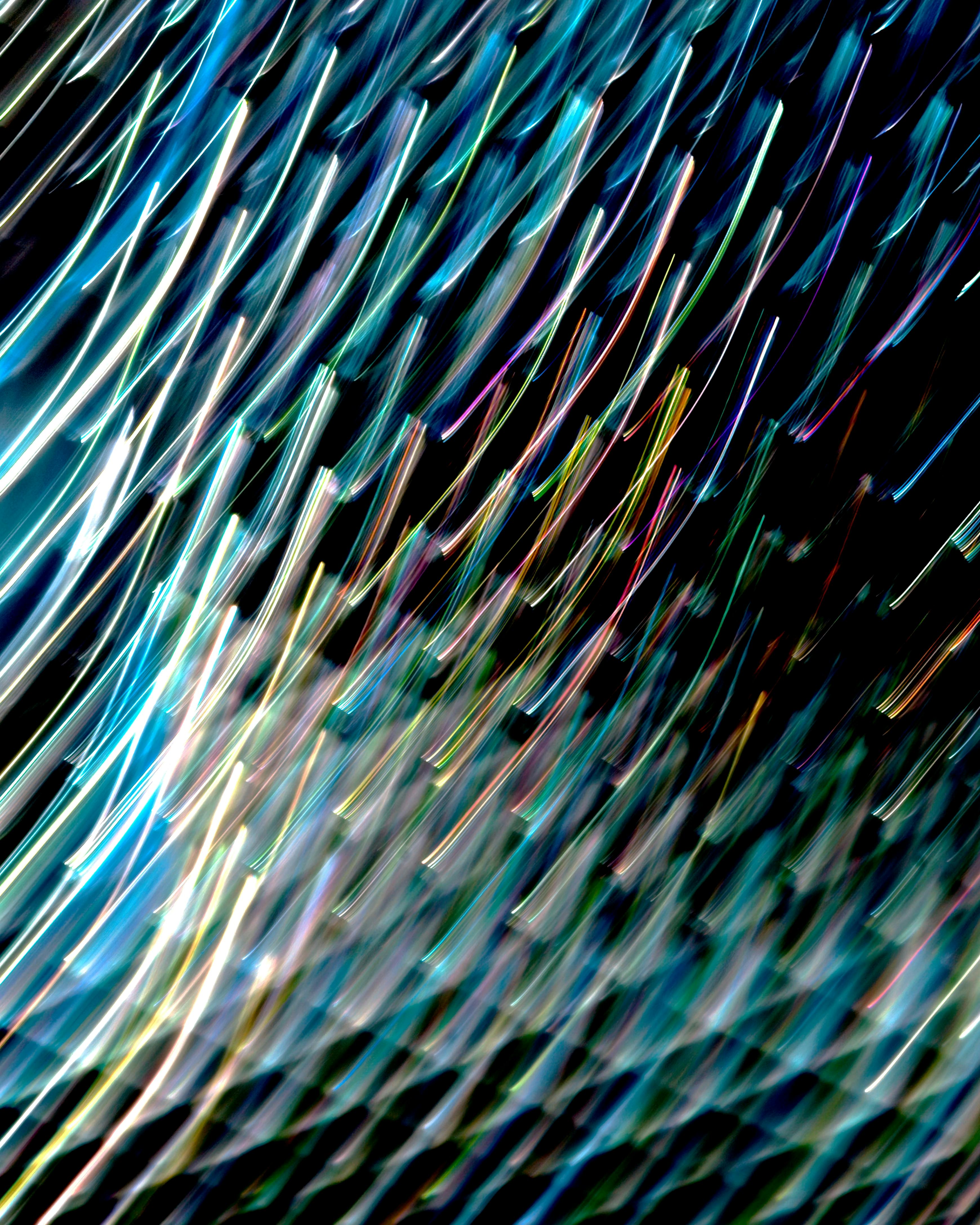 Vibrant abstract light trails forming dynamic patterns against a dark backdrop.