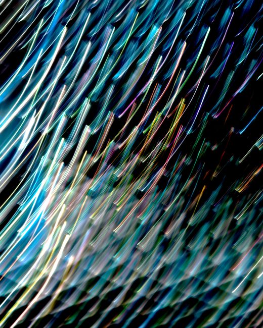 Vibrant abstract light trails forming dynamic patterns against a dark backdrop.