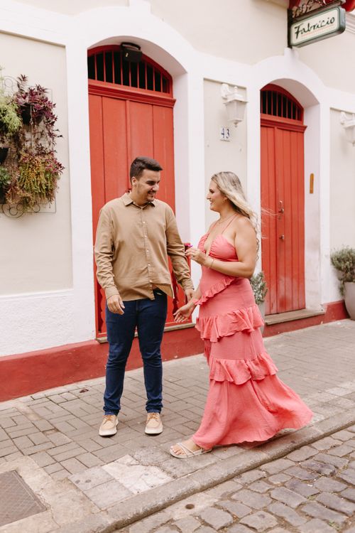 Free Fashionable couple strolling by vibrant red doors in a charming urban location. Stock Photo