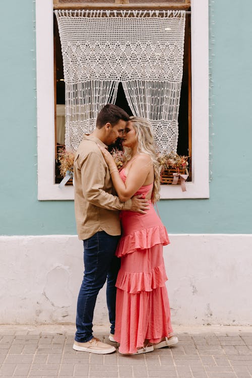 Couple kissing in front of colorful building