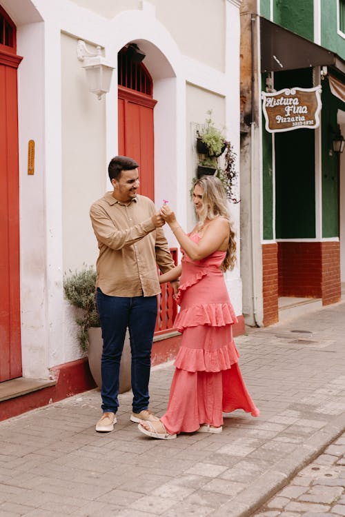 A couple is standing in front of a red building