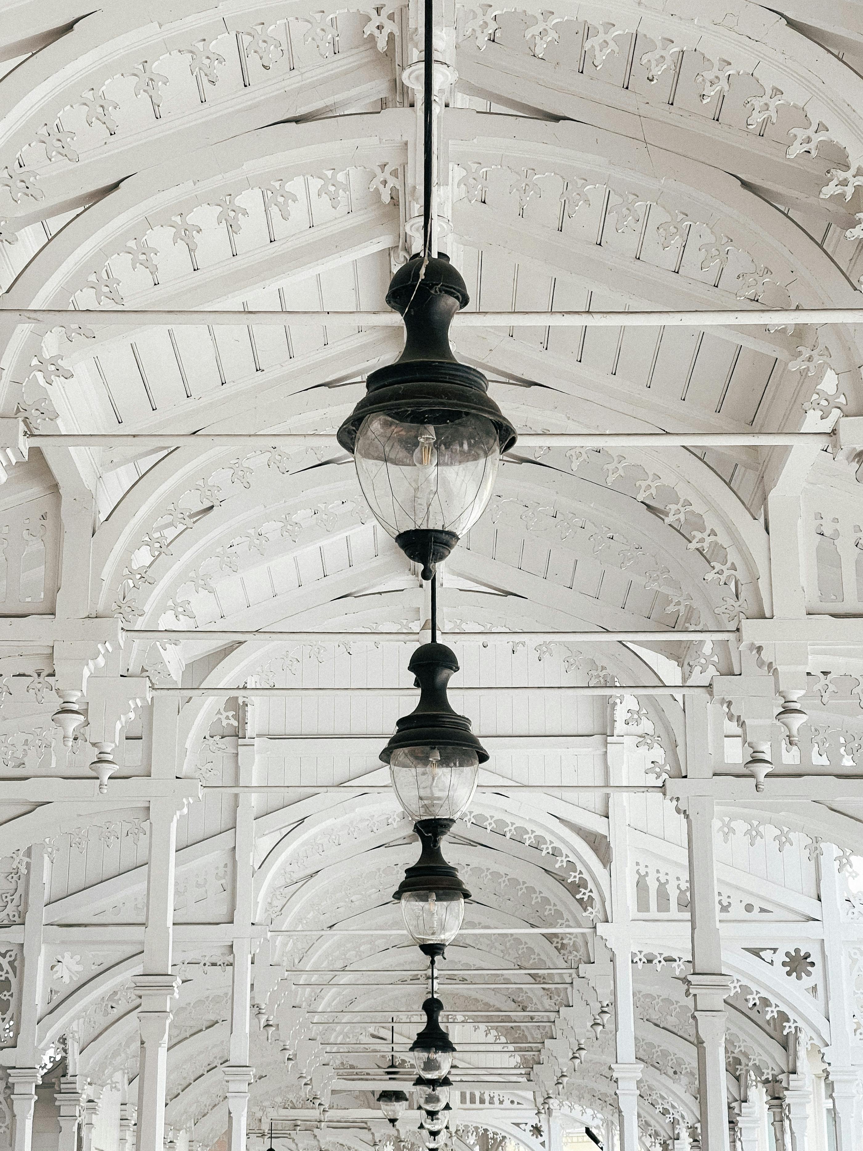 Beautiful white colonnade in Karlovy Vary with ornate details and hanging lanterns.