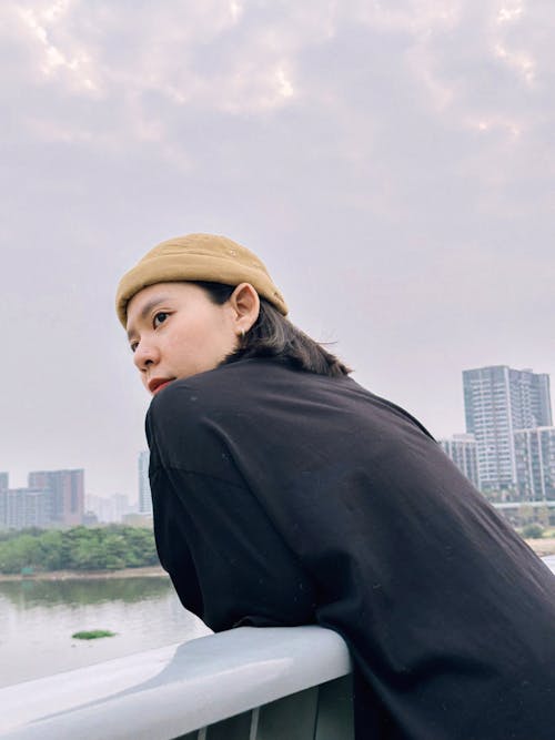 Woman in Hat Leaning on Railing