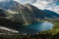 宁静的山湖景色令人惊叹，四周环绕着郁郁葱葱的森林和雄伟的山峰