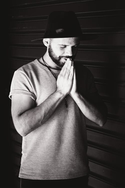 Grayscale Photo of Man Praying