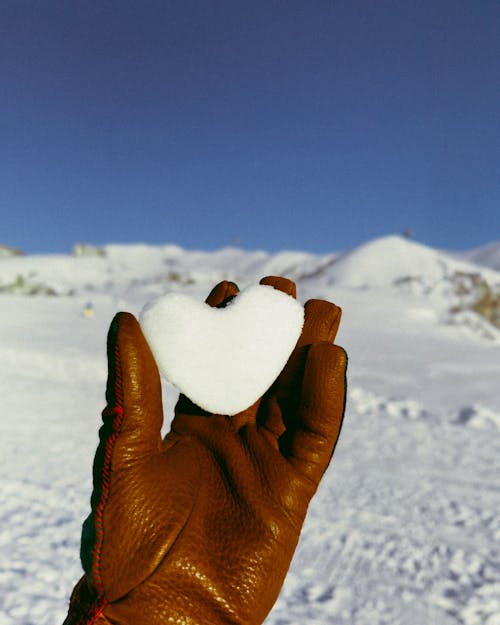 Hand Holding Snowball in Heart Shape