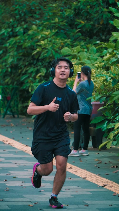 Free A man running in a park with other people Stock Photo