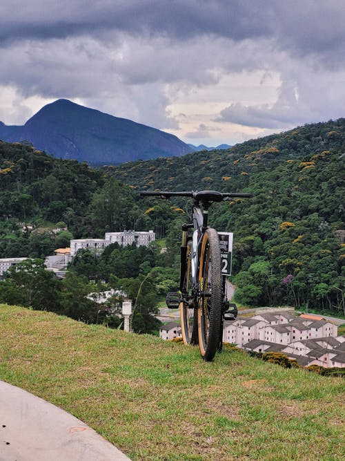 A bicycle leaning against a hillside with a view of mountains