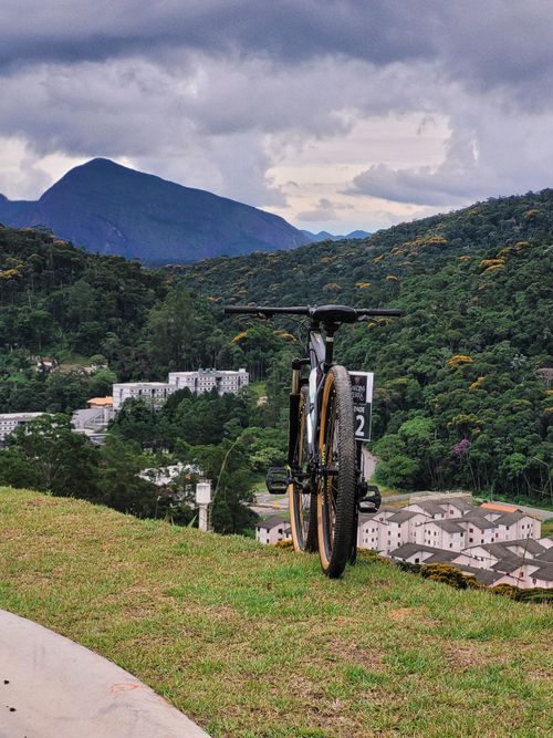 Free Mountain bike on hilltop overlooking lush green village with mountains in the backdrop. Stock Photo