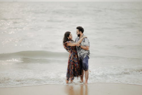A Couple Hugging while Standing Ankles Deep in the Sea