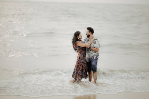 A Couple Hugging while Standing Ankles Deep in the Sea