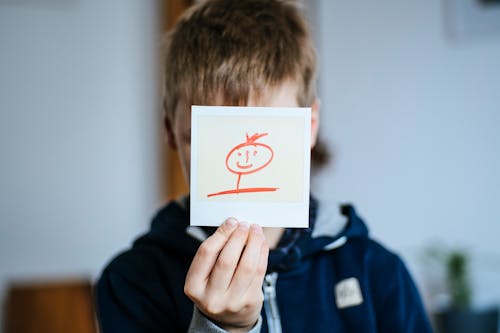 Boy in Blue Jacket Holding White Printer Paper