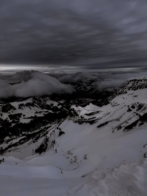 Scenic View of Snowcapped Mountains under Dramatic, Dark Clouds 