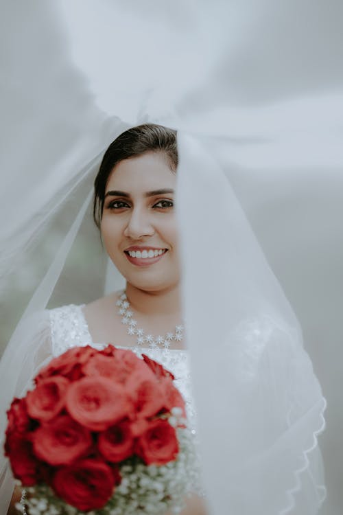 A bride with a veil and red roses