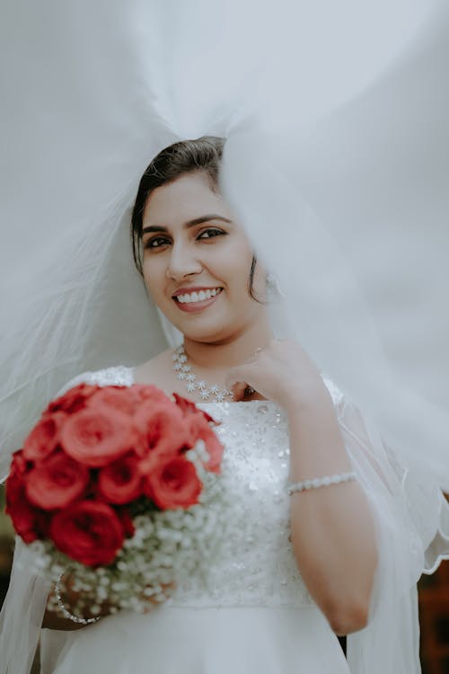 A bride holding a bouquet and veil