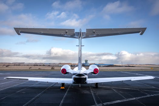 Back view of a private jet stationed at Sylt Airport with clear skies.