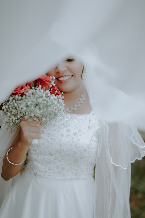 Photo of a Smiling Bride Holding a Bouquet