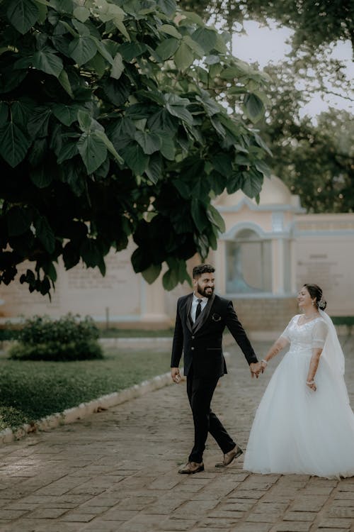 Newlyweds Holding Hands and Walking Together