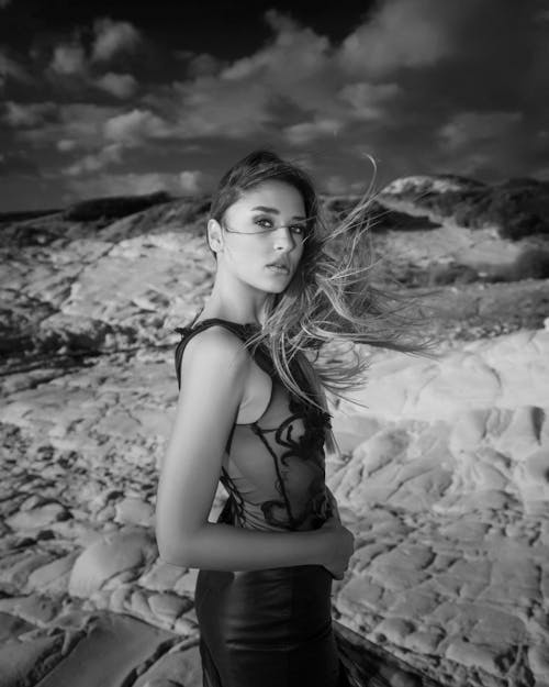 A woman in a black dress standing on a beach