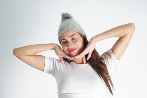 Smiling Woman in Hat Stretching with Eyes Closed