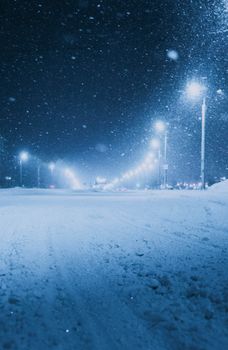 Captivating winter scene of a snowy street in Vitebsk, Belarus, with glowing streetlights.