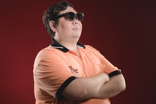A man in sunglasses and an orange shirt