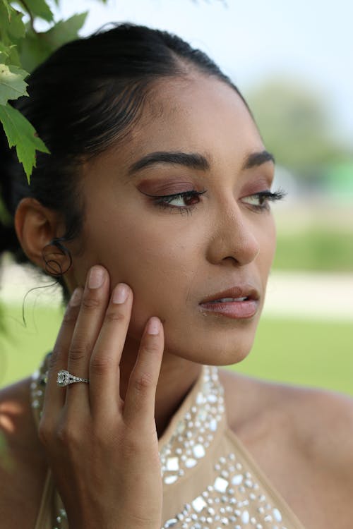 A woman with her hands on her face and a ring on her finger