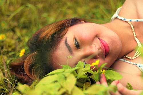 Free Portrait of a Young Woman Relaxing on Grass Stock Photo