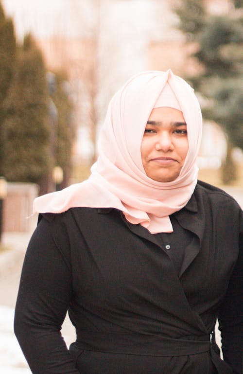 A woman in a black shirt and pink scarf