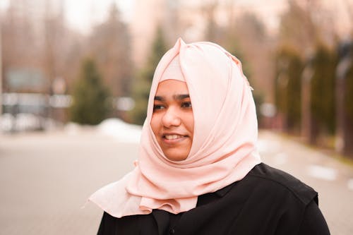 A woman in a pink hijab smiling