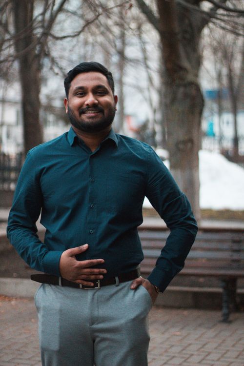 Free A well-dressed man smiling confidently in an outdoor setting during daytime. Stock Photo