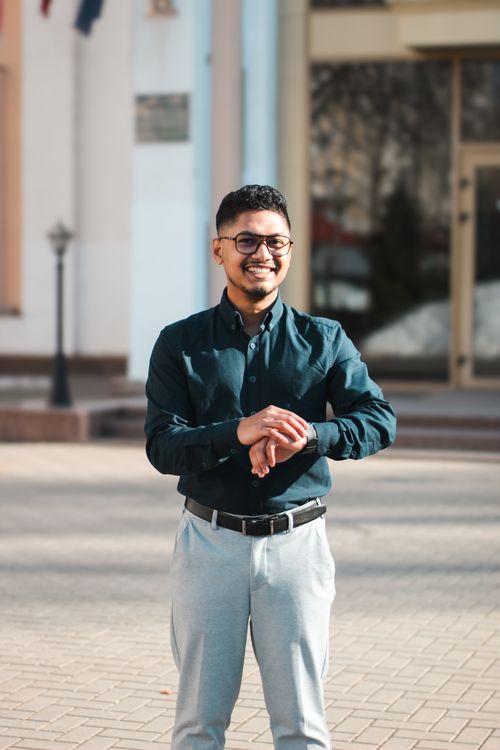 Free Portrait of a well-dressed young man smiling confidently outdoors. Perfect for fashion and lifestyle concepts. Stock Photo