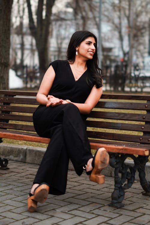 A woman in black sitting on a bench