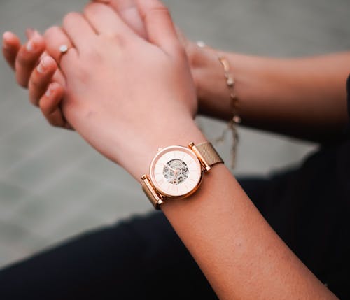 A woman wearing a gold watch on her wrist