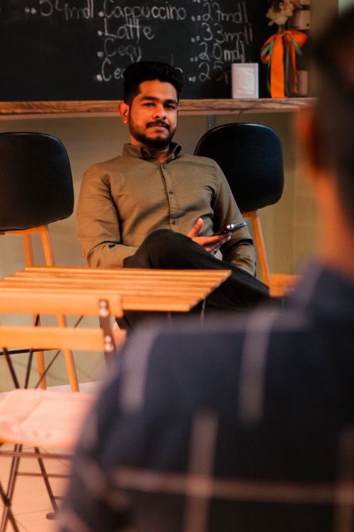 Free Man sitting comfortably in a cozy café, capturing relaxed modern ambiance. Stock Photo