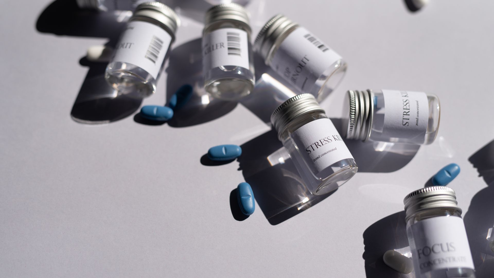 Microdosing Modafinil: Unlocking Focus and Productivity Close-up of medicine bottles and blue pills on a white background, emphasizing healthcare.