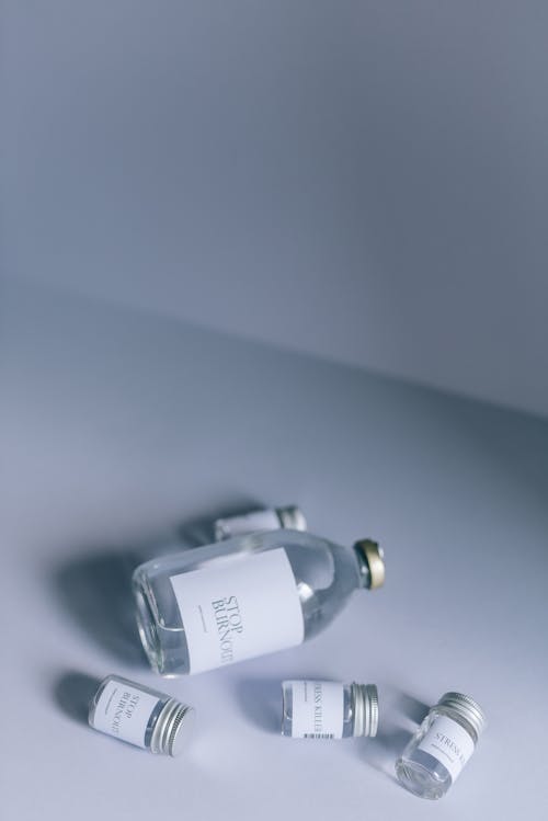 Бесплатное стоковое фото с белый фон, бутылки, вертикальный выстрел