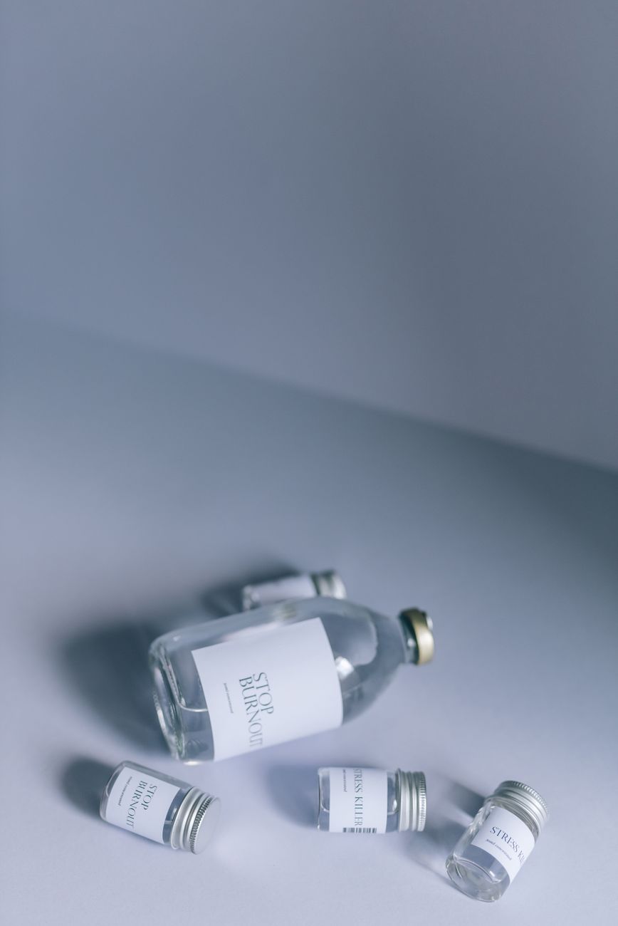 Still life of glass medicine bottles against a soft white backdrop, showcasing minimalism.