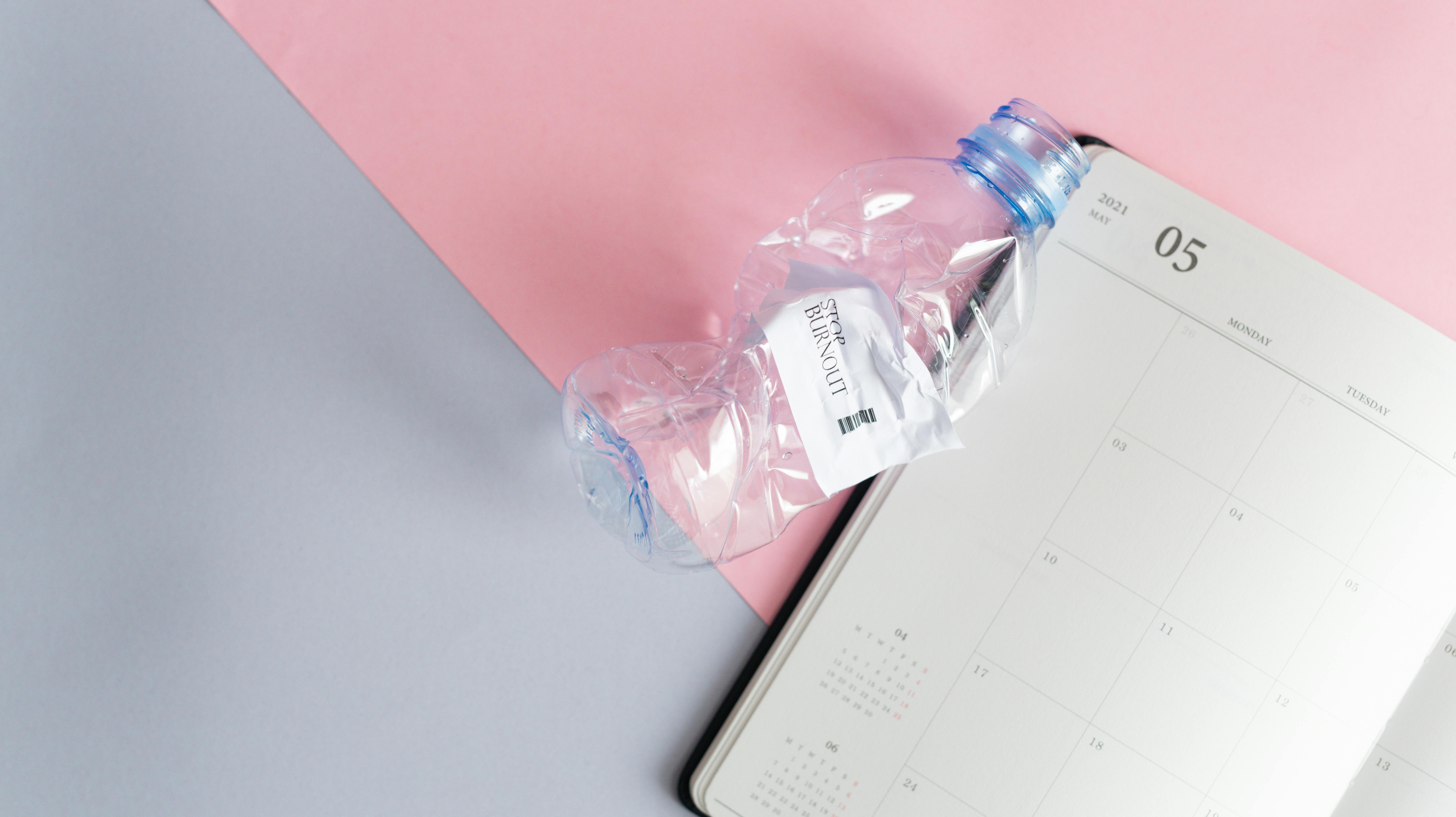 empty page in a calendar and a scrunched plastic water bottle