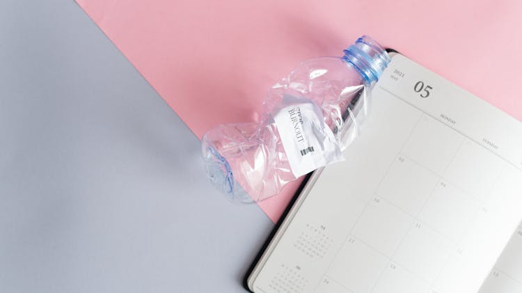 Empty Page In A Calendar And A Scrunched Plastic Water Bottle 