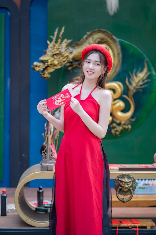 A woman in a red dress holding a red box
