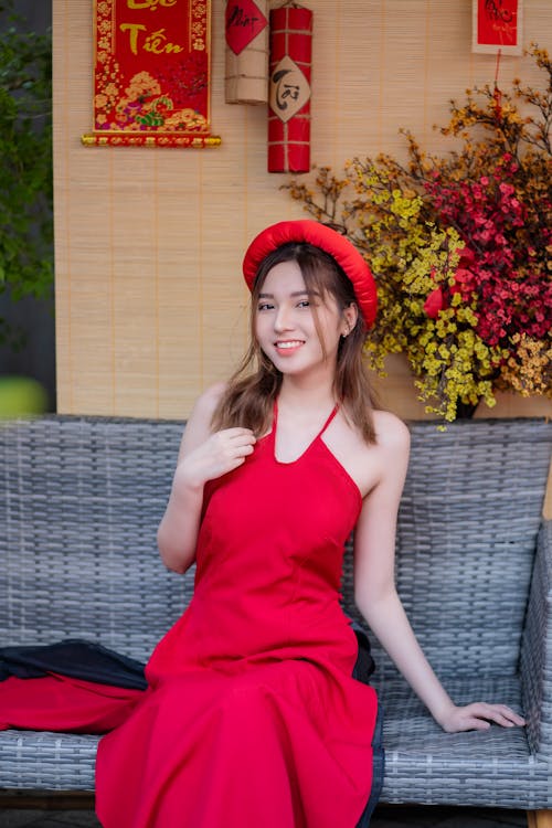 A woman in a red dress sitting on a bench