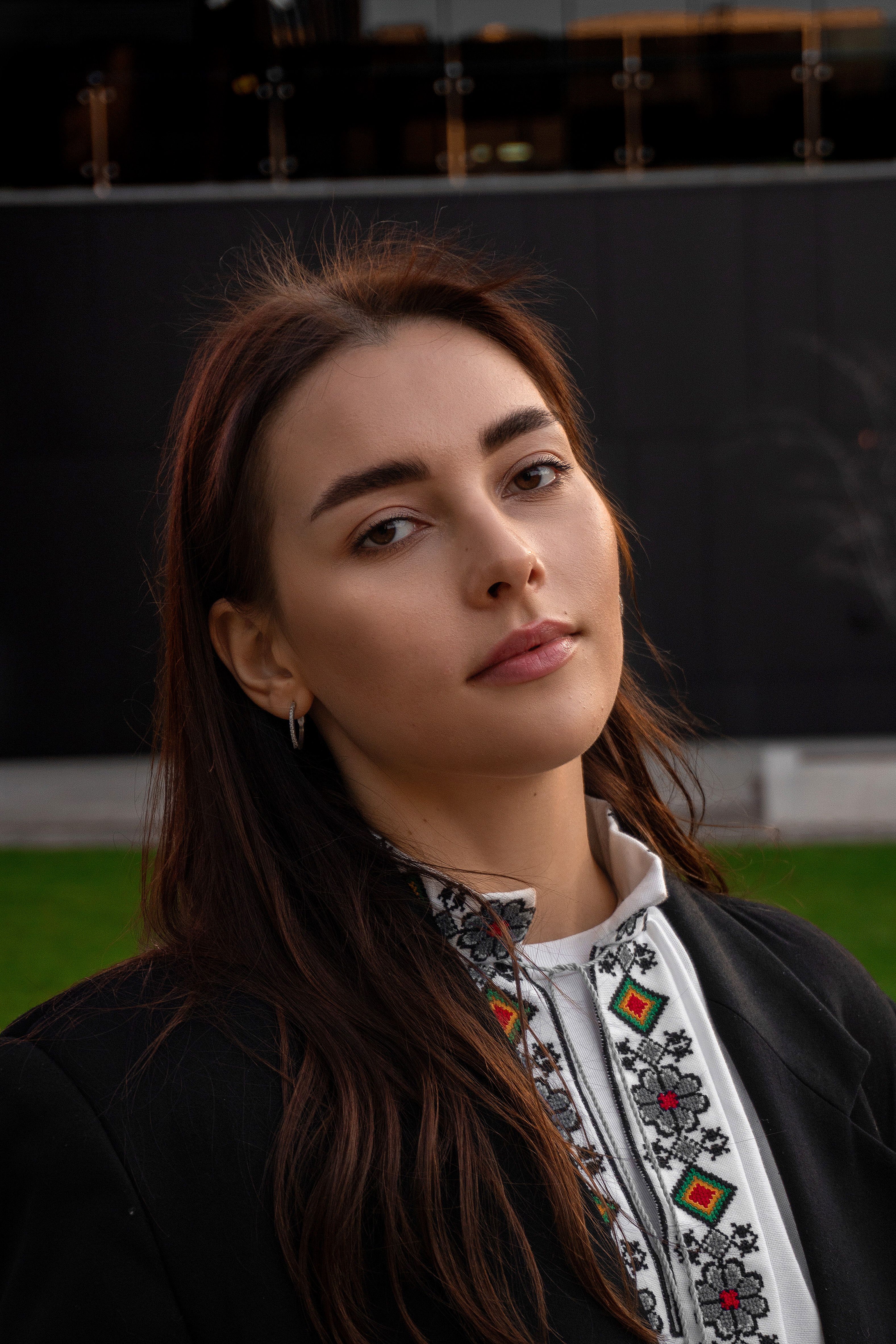Portrait of a woman outdoors in traditional embroidered clothing, exuding confident elegance.