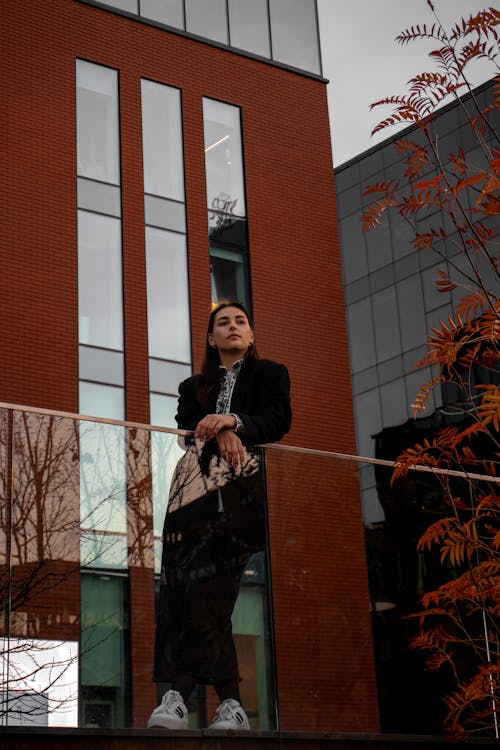 Woman Leaning on Railing in City