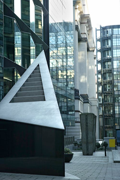 A sculpture in front of a building with tall buildings