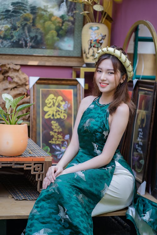 A woman in a green dress sitting on a chair